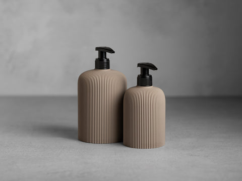 SVEA Seifenspender in Beige, 250 ml und 500 ml, mit schwarzer Pumpe und feiner vertikaler Struktur.