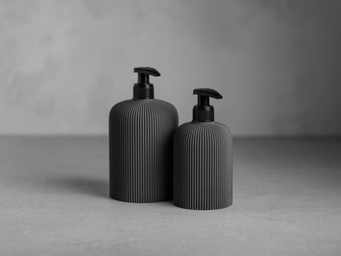 SVEA Seifenspender in Eisengrau, 250 ml und 500 ml, mit schwarzer Pumpe und feiner vertikaler Struktur.