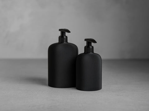 SVEA Seifenspender in Graphitschwarz, 250 ml und 500 ml, mit schwarzer Pumpe und feiner vertikaler Struktur.