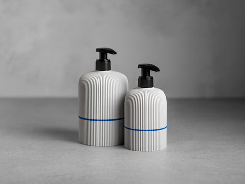 SVEA Seifenspender in Juppô Weiss, 250 ml und 500 ml, mit schwarzer Pumpe und feiner vertikaler Struktur.