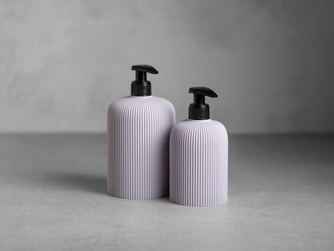 SVEA Seifenspender in Lavendel, 250 ml und 500 ml, mit schwarzer Pumpe und feiner vertikaler Struktur.