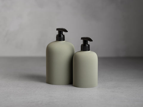 SVEA Seifenspender in Nebelgrün, 250 ml und 500 ml, mit schwarzer Pumpe und feiner vertikaler Struktur.